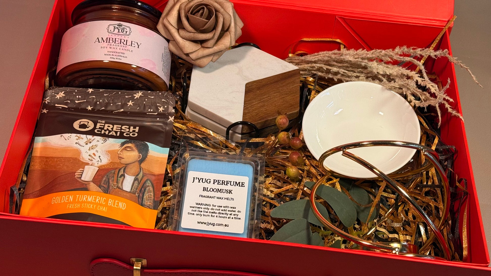 Luxury gift hamper in red magnetic box with cream ribbon and floral decoration